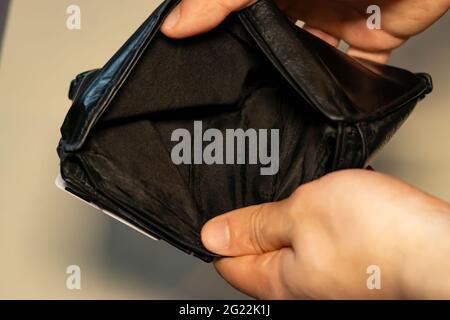Halten Sie eine Brieftasche ohne Geld. Leere Brieftasche. Arm, arbeitslos. Stockfoto