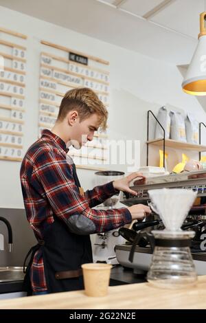 Barista, der Kaffee mit einer Kaffeemaschine zubereitet Stockfoto