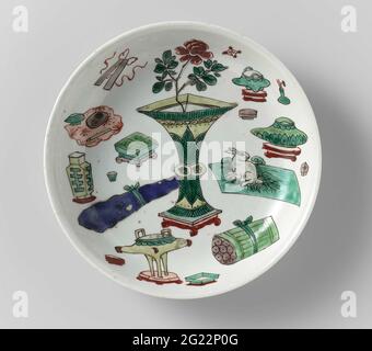 Untertasse mit wertvollen Gegenständen und Antiquitäten. Schüssel mit runden Wand aus Porzellan, in Unterglasur blau und auf der Glasur blau, rot, grün, gelb, Auberginen und schwarz gemalt. Auf den flachen chinesischen Antiquitäten; der Boden mit vier Wertsachen. Auf der Unterseite mit dem vierstelligen Zeichen von Kaiser Xuande in einem Doppelkreis gekennzeichnet. Späne in der Kante; drei Risse in der Kante. Famille Verte. Stockfoto