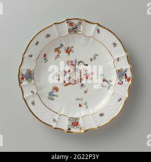 Runder Teller, mehrfarbig bemalt mit kakiemon-Dekor. Runder Teller aus bemaltem Porzellan. Die Platte ist gerippt und hat eine abgeschrägte Kante. Die Platte ist mit einem Tiger bemalt, der um einen blauen Bambusstiel zwischen Blumen, bestreuten indischen Blumenstrauß, Schmetterlingen und Ästen, auf denen Vögel gedreht wurde. Der Rand ist mit dem Muster 'Altbrandenstein' verziert. Die Platte wurde markiert. Stockfoto