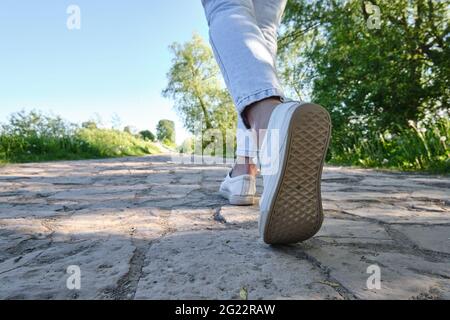 Ein Mann geht die Straße entlang. Nahaufnahme eines Fußes. Ansicht von unten, Rückansicht. Stockfoto