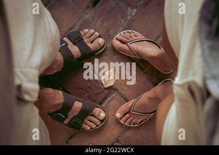 Draufsicht auf Männer und Frauen, die Sandalen und Flip-Flops tragen und einander gegenüberstehen. Sommer, Abenteuer, Rucksackreisen, Reisekonzept. Stockfoto