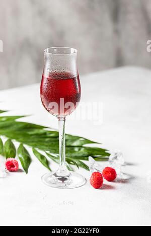 Beerenalkoholischer Cocktaillikör, Wodka, Eis und Minze. Erfrischendes kühles Getränk, Beerenlikör oder roter alkoholischer Cocktail. Selektiver Fokus Stockfoto