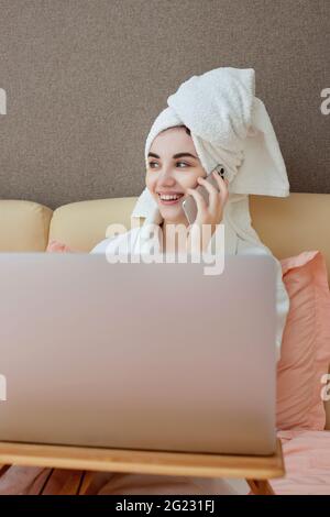 Junge wunderschöne kaukasische Frau in weißen Bademänteln und Handtüchern Köpfe Stockfoto