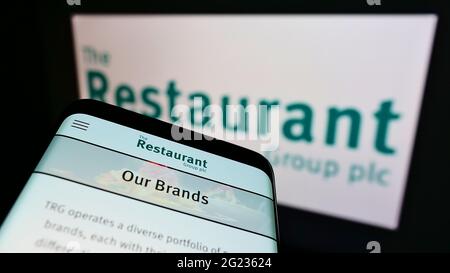 Mobiltelefon mit Website des britischen Gastronomieunternehmens The Restaurant Group plc auf dem Bildschirm vor dem Logo. Konzentrieren Sie sich auf die obere linke Seite des Telefondisplays. Stockfoto