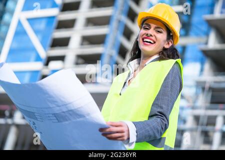 Weibliche Architekt Studium Entwürfe beim Besuchen der großen Baustelle Stockfoto