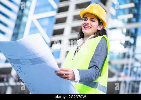 Weibliche Architekt Studium Entwürfe beim Besuchen der großen Baustelle Stockfoto