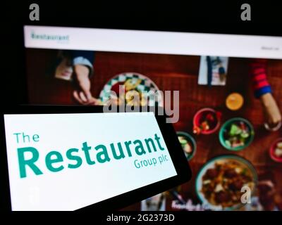 Handy mit Logo des britischen Gastronomieunternehmens The Restaurant Group plc auf dem Bildschirm vor der Website. Konzentrieren Sie sich auf die Mitte rechts des Telefondisplays. Stockfoto