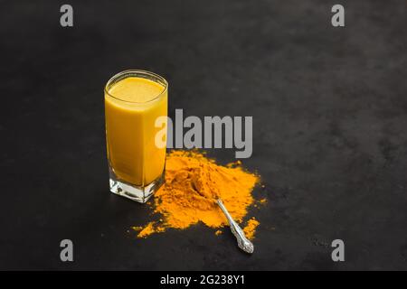 Goldene Milch, Kurkuma Latte, Goldener Latte auf dunklem Hintergrund, Gewürze Indiens gesunde Ernährung Stockfoto