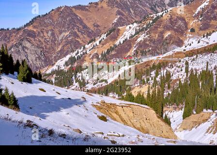 Winterlandschaft mit bunten Häusern, die Folgen eines Schlammflusses im Bett eines Bergflusses; Flusstal nach Schlammfluss in der Wintersaison Stockfoto