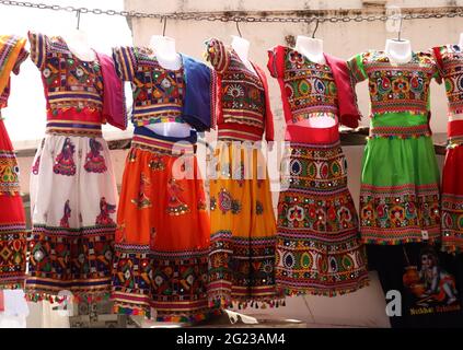 Indische traditionelle, bunte Kleider hängen an der Kette auf dem Markt Stockfoto