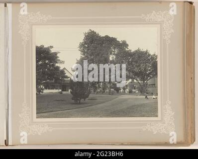 Sam von Musschenbroek auf dem Gelände rund um das Haus. Blick auf das Grundstück rund um das Haus mit Garten, Rasen und Bäumen. Auf einem Weg bei einer Taubenpille ist mit seiner Tochter bei Sam von Musschenbroek. Teil des Fotoalbums über die Zuckerfabrik Tjomal (Comal) auf Java im Zeitraum 1890-1910. Stockfoto