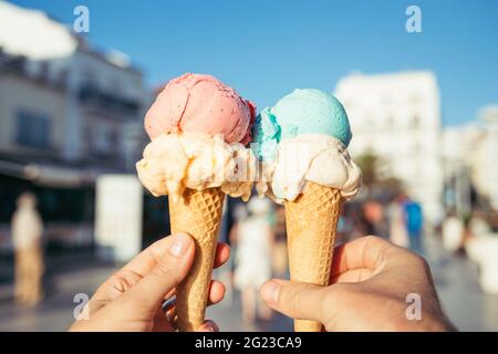Hände mit Eiscreme in Waffelkonen. Stockfoto