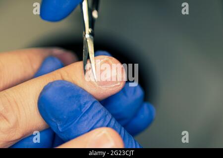 Der Mann für Verfahren in Maniküre Salon. Wellness, manicuring, Entfernen der Nagelhaut Schere. Schönen männlichen Händen. Stockfoto