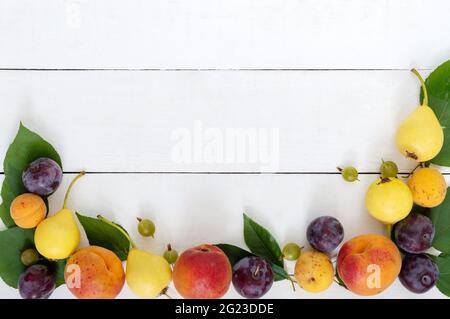 Frische Früchte auf weißem Holzhintergrund. Speicherplatz kopieren. Stockfoto