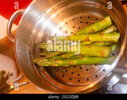 Kochen von englischem Spargel in einem Dampfgarer Stockfoto