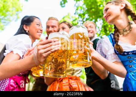 Freunde, zwei Männer, drei Frauen, stehend im Biergarten mit Bier Gläser Stockfoto