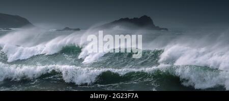 Ein Panoramabild von wilden Wellen, die brechen und das raue Meer Rund um die Goose Island vor der Landspitze von Pentire Point East In Fistral Bay in Newquay in Cornw Stockfoto