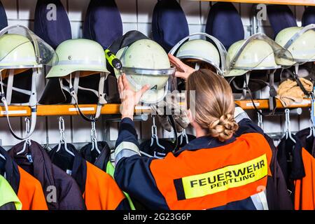 Weibliche fire fighter in der Umkleide mit Helm in Brand alarm Situation Stockfoto