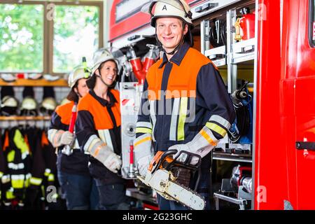 Professionelle Feuerwehr Befestigung Schlauch an Schlauch Verlegung vehiclero Stockfoto