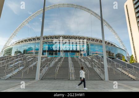 Wembley Stadium, Wembley Park, Großbritannien. Juni 2021. Passanten laufen vor dem Wembley-Stadion und den neu errichteten olympischen Stufen vor der UEFA Euro 2020. Das Turnier wurde um ein Jahr verschoben, als die Coronavirus-Pandemie 2020 weltweit eintraf, und beginnt in 3 Tagen, am 11. Juni 2021, mit dem Wembley Stadium, dem ersten Spiel, England gegen Kroatien, am 13. Juni 2021. Amanda Rose/Alamy Live News Stockfoto