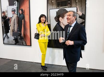 Berlin, Deutschland. Juni 2021. Der ehemalige Bundeskanzler Gerhard Schröder und seine Frau Soyeon Schröder-Kim stehen bei der Eröffnung der Ausstellung 'Diversity United' vor großformatigen Fotos von Boris Mikhailov. Die Ausstellung soll das künstlerische Gesicht Europas zeigen. In der Ausstellung der Stiftung für Kunst und Kultur im Hangar 2 auf dem ehemaligen Flughafen Tempelhof sind von 09.06.2021 bis 19.09.2021 rund 90 Künstler aus 34 europäischen Ländern zu sehen. Quelle: Bernd von Jutrczenka/dpa/Alamy Live News Stockfoto