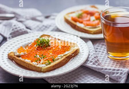 Sandwiches oder Tapas mit Brot, rotem Kaviar und rotem Fisch mit Mikrogemüse, Meeresfrüchten Luxus-Delikatessen Stockfoto