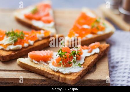 Sandwiches oder Tapas mit Brot, rotem Kaviar und rotem Fisch mit Mikrogemüse, Meeresfrüchten Luxus-Delikatessen Stockfoto