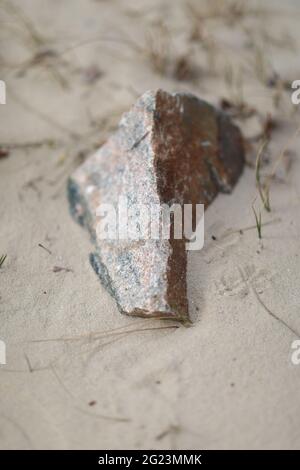 Nahaufnahme eines Steines an einem sandigen Ufer Stockfoto