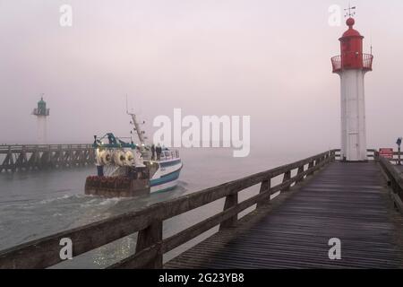 Trouville sur Mer (Normandie, Nordwestfrankreich): Fischerboot, das an einem nebligen Tag den Hafen verlässt Stockfoto