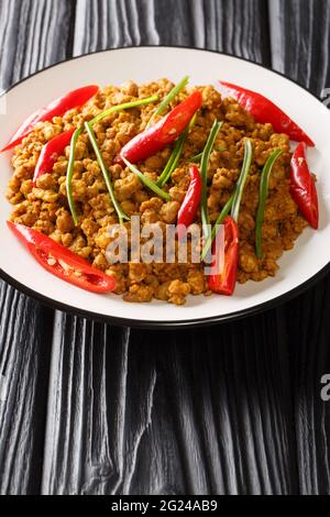 Khua kling ist ein würziges, trocken gebratenes Kerry aus der thailändischen Küche in der Nähe auf dem Teller auf dem Tisch. Vertikal Stockfoto