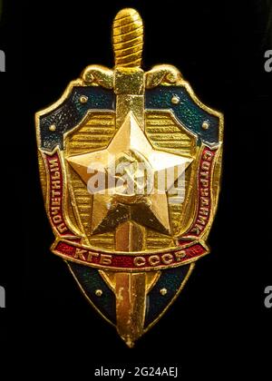 Bildliches, repräsentatives Bild des Abzeichen / Insignien der KGB-Sicherheitsbehörde, angebracht an einer Metallflasche (vom Fotografen selbst) - schwarzer Hintergrund. Stockfoto