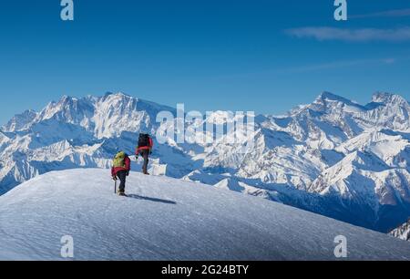 Frankreich, Haute Savoie, Chamonix, Bergsteiger, die den schneebedeckten Hang im Gebiet des Mont Blanc erklimmen Stockfoto