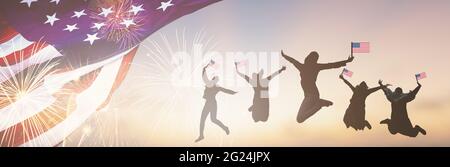 Silhouetten Gruppe von Menschen mit der Flagge der USA springen in Amerika feiern Feuerwerk am 4. Juli. Winken von fröhlichen amerikanischen Flaggen bei Sonnenuntergang. Menge Stockfoto