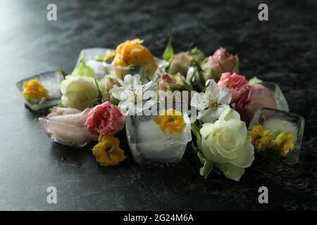 Blumen und Eiswürfel auf schwarzem rauchigen Hintergrund Stockfoto