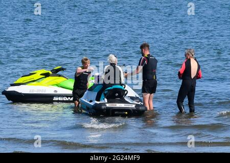 Poole, Dorset, Großbritannien. Juni 2021. Wetter in Großbritannien. Die Leute, die am Ende der Slipanlage im Harborside Park in Poole in Dorset auf Jetskis steigen, genießen die heiße Nachmittagssonne. Bildnachweis: Graham Hunt/Alamy Live News Stockfoto