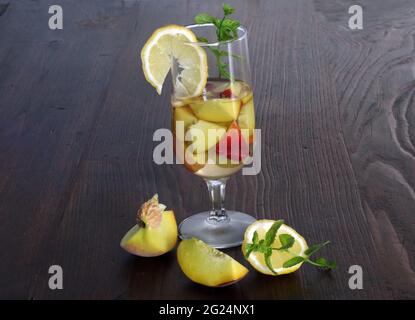 Pfirsich in Weißwein mit Zitronen- und Minzblättern Stockfoto