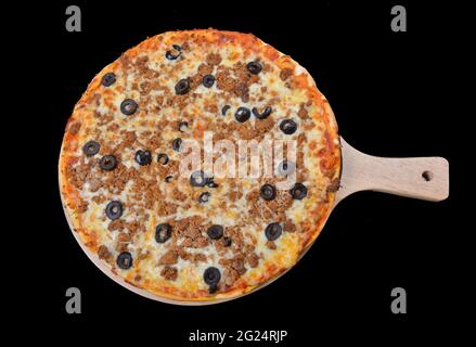 Hackfleischpizza mit schwarzen Oliven auf schwarzem Hintergrund Stockfoto