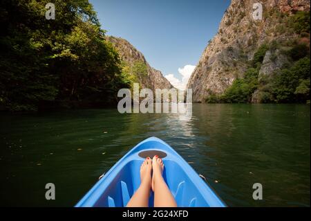 Kajak durch Fluss in Matka Canyon, Mazedonien. Frau Beine in der blauen Kajak Stockfoto