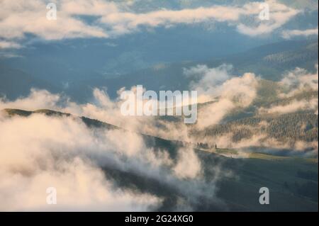 Niedrige Wolken und Berge Silhouetten. Picturecque Berglandschaft nach dem Regen Stockfoto