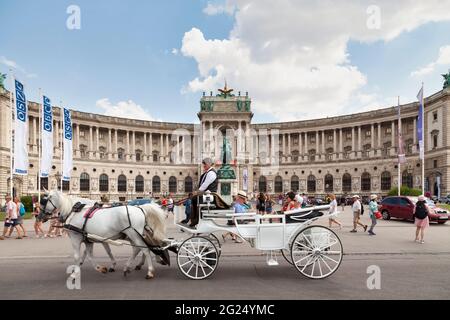 Wien, Österreich - Juni 17 2018: Kutschfahrt vor der Österreichischen Nationalbibliothek im Neuen Burgflügel der Hofburg Stockfoto