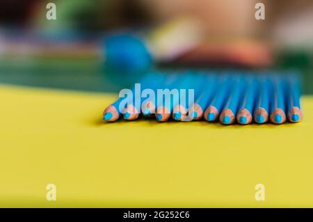 Geschärfte blaue Bleistifte auf gelbem Hintergrund. Stockfoto