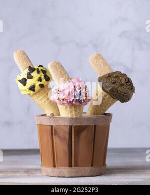 Vertikale Aufnahme von Eiscreme mit verschiedenen Geschmacksrichtungen in Waffelkonen Stockfoto