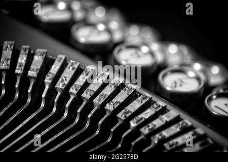 Vintage-Keyboarding auf einer klassischen Schreibmaschine der 20er Jahre mit Bokeh-Tastatur und schwarzem Hintergrund. Geeignet für Geschäftsbüros und Hotelzimmer oder Lobbys. Stockfoto