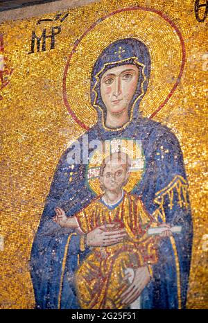 Detail des Comnenus-Mosaiks, Hagia Sophia (türkisch: Ayasofya), Istanbul, Türkei. Die Jungfrau Maria in einem dunkelblauen Kleid hält das Christkind auf ihrem Schoß. Er segnet mit seiner rechten Hand, während er eine Schriftrolle in seiner linken hält. Byzantinische Kunst Stockfoto