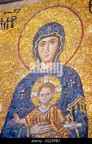 Detail des Comnenus-Mosaiks, Hagia Sophia (türkisch: Ayasofya), Istanbul, Türkei. Die Jungfrau Maria in einem dunkelblauen Kleid hält das Christkind auf ihrem Schoß. Er segnet mit seiner rechten Hand, während er eine Schriftrolle in seiner linken hält. Byzantinische Kunst Stockfoto