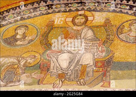 Detail des Kaiserlichen Tormosaiks, Hagia Sophia (türkisch: Ayasofya), Istanbul, Türkei. Der Kaiser mit einem Nimbus oder Heiligenschein könnte möglicherweise Kaiser Leo VI. Der Weise oder seinen Sohn Konstantin VII. Porphyrogenitus darstellen, der sich vor Christus Pantokrator verneigt, auf einem Thron mit Juwelen sitzt, seinen Segen gibt und in seiner linken Hand ein offenes Buch hält. Stockfoto