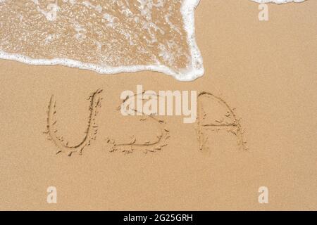 Wort USA handgeschrieben auf dem Sand des Strandes Stockfoto