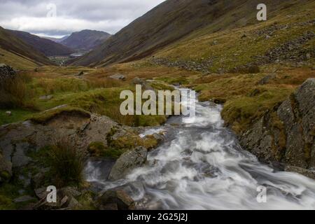 Ein Gebirgsbach fließt vom Kirkstone Pass im Lake District in Cumbria, England, hinunter Stockfoto