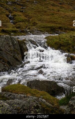 Ein Gebirgsbach fließt vom Kirkstone Pass im Lake District in Cumbria, England, hinunter Stockfoto